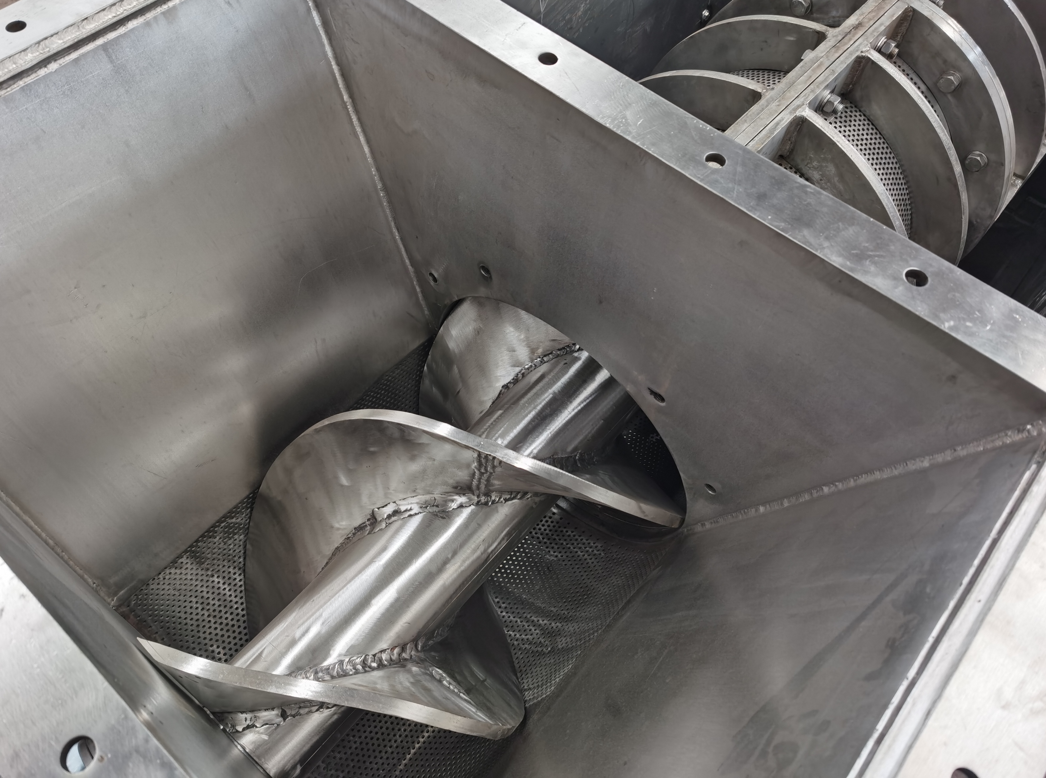 How does the design of the screw press dehydrator affect the squeezing efficiency and material juice yield?
